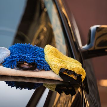 cleaning equipment over the bonnet of a black clean car