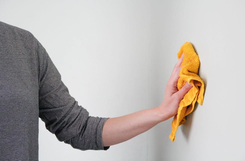 person dusting wall