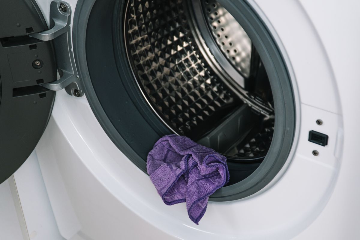 purple rag resting on edge of washing machine