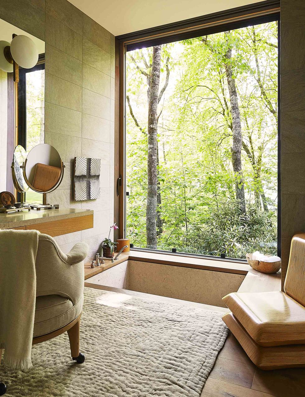 bathroom with sunken tub and window overlooking wooded area