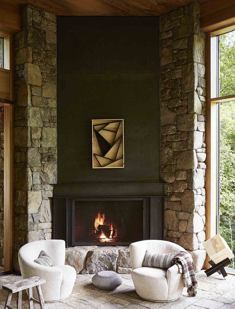 two chairs in front of a stone fireplace