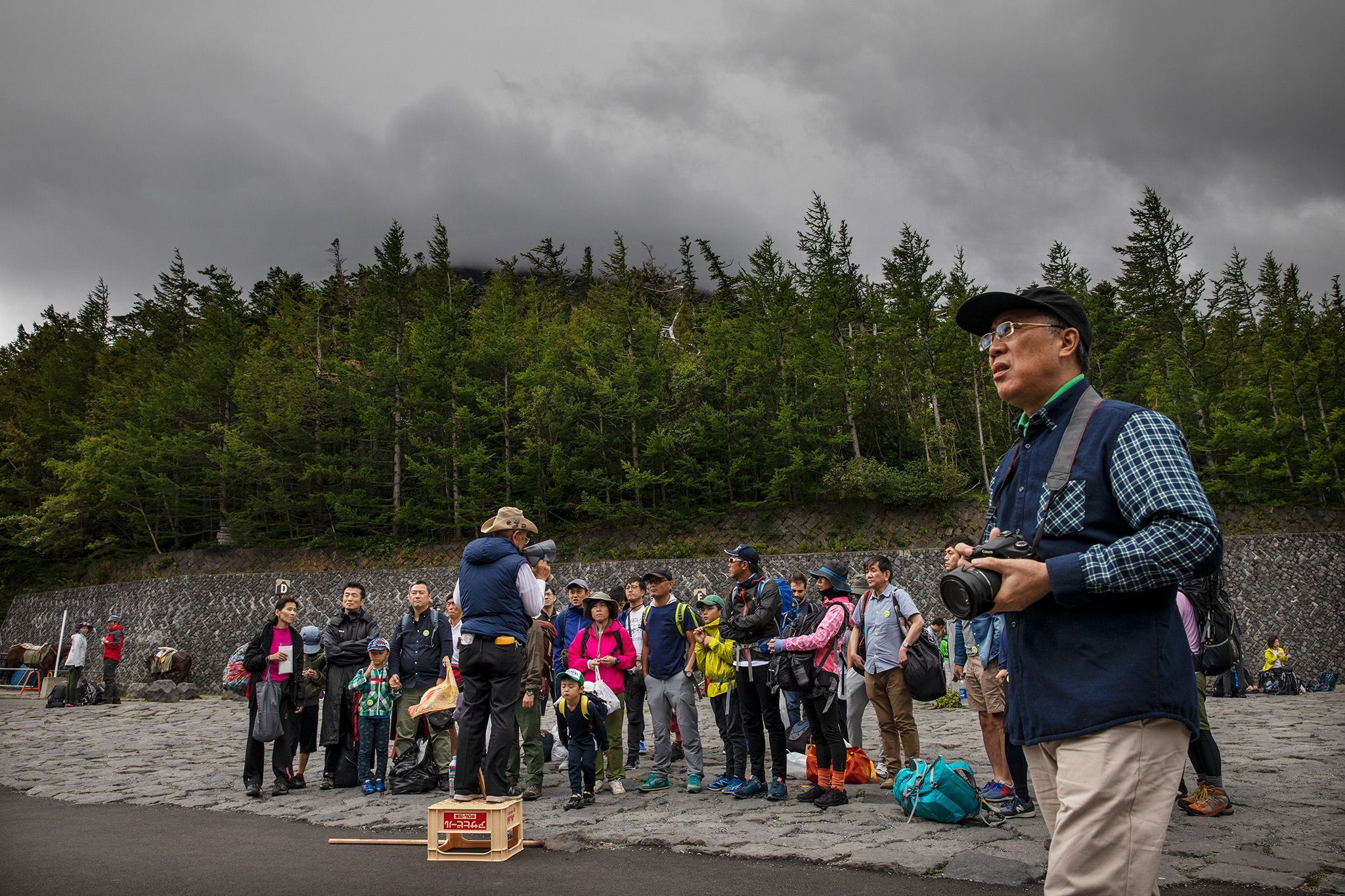 een groep mensen verzamelt zich op het yoshidapad om te beginnen aan een poging om de top van de berg fuji te bereiken