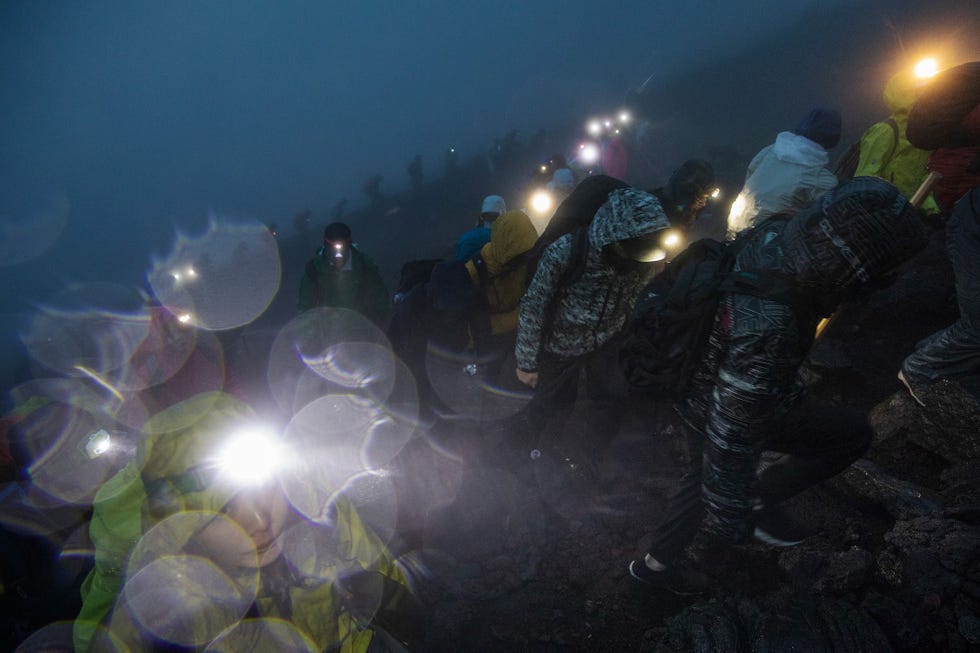 Mensen beginnen in de vroege ochtend aan hun klim naar de top van de Fuji Je kijkt om en ziet duizenden mensen zigzaggend de berg op lopen allemaal met hoofdlampen op zegt Guttenfelder Het ziet eruit als een bedevaart het lijkt alsof iedereen een lampion met zich meedraagt