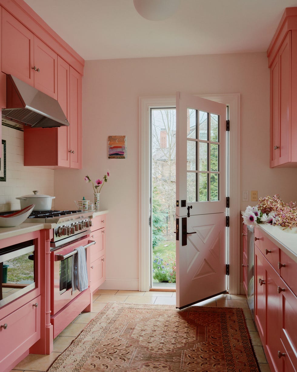 bright kitchen with pink cabinetry and an open door to the garden bright kitchen with pink cabinetry and an open door to the garden