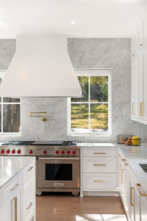 white kitchen with gold hardware and marble backsplash