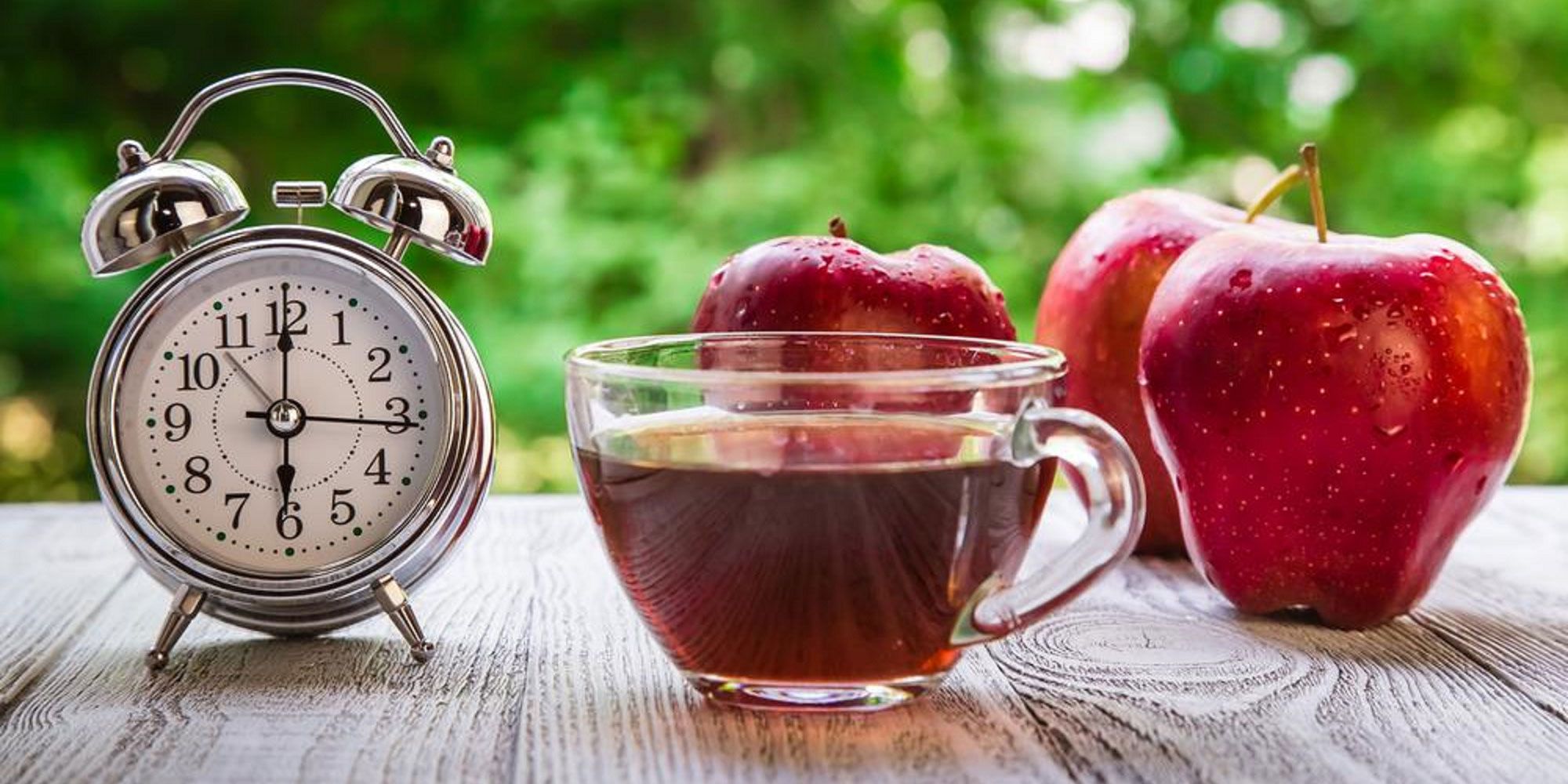 Clock with apples and a cup of tea