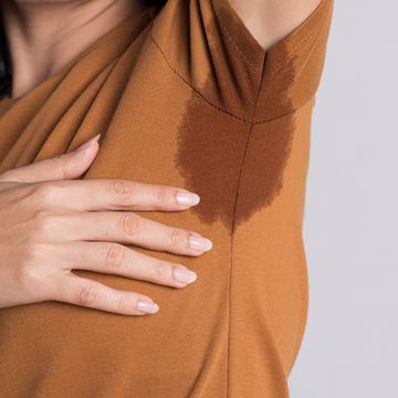 close up asian woman with hyperhidrosis sweating young asia woman with sweat stain on her clothes against grey background healthcare concept