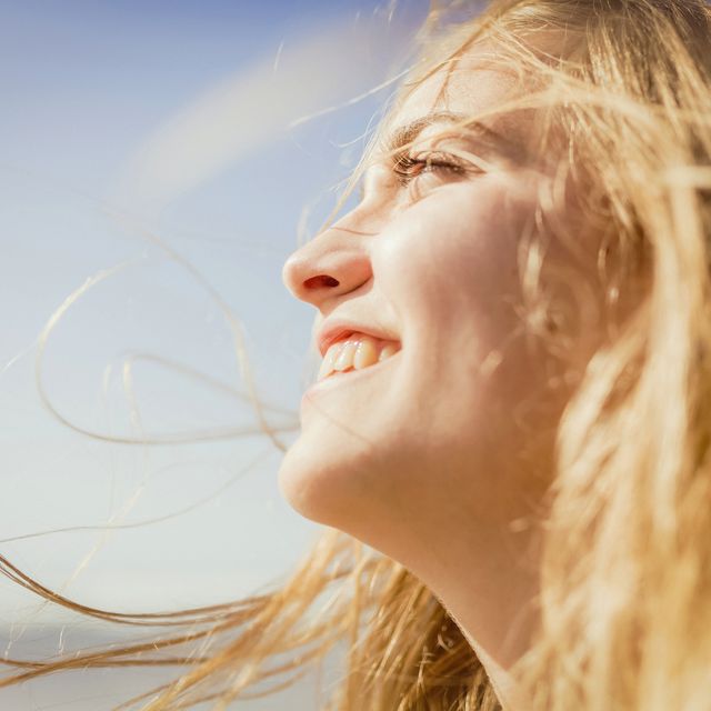 close up carefree, smiling woman enjoying sunshine