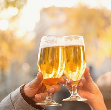 Close up couple toasting beer glasses at autumn cafe