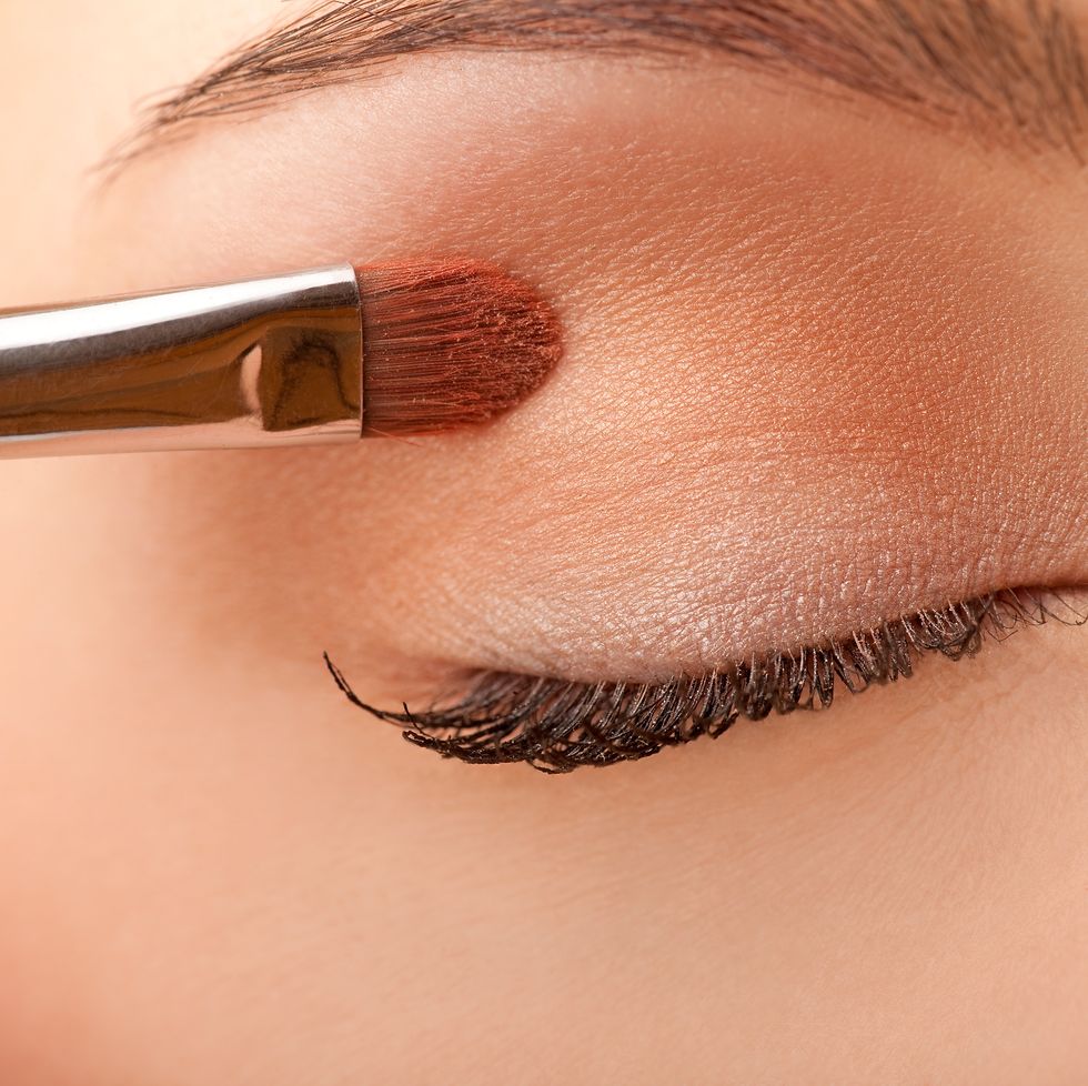 close up female applying make up