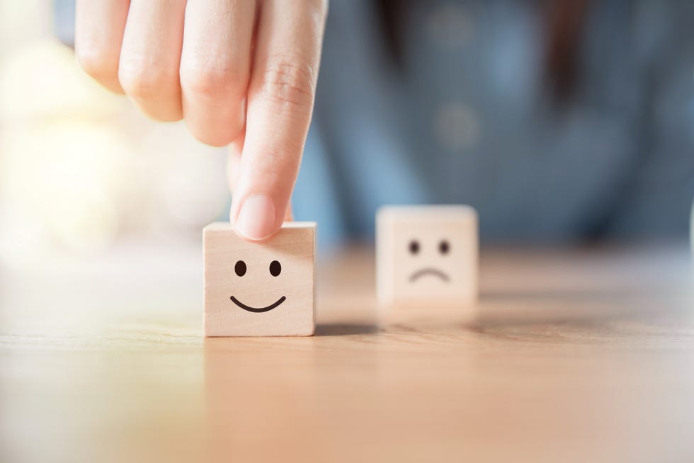 a pair of wooden blocks, one with a happy face and the other with a sad face