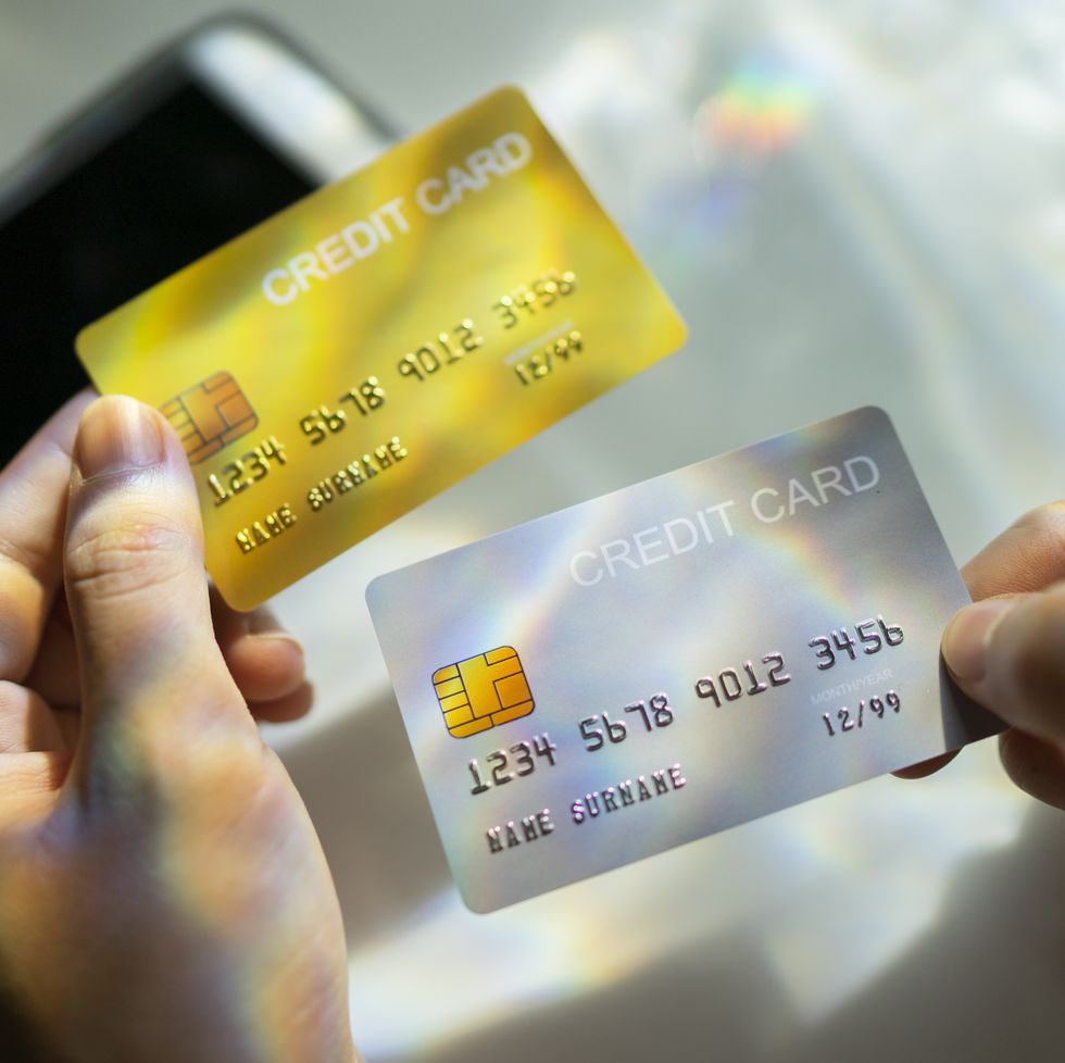 close up hand holding blank credit card black,gold,platinum color with spectrum light and shadow background