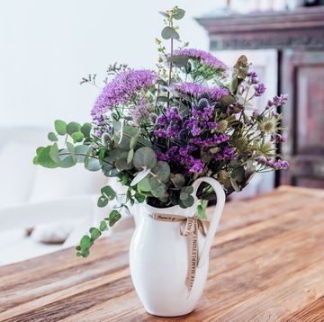 Close-up image of vase with lilac flowers on a wooden table (indoors)
