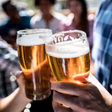 close up of a customers at a bar holding a beer and making a toast