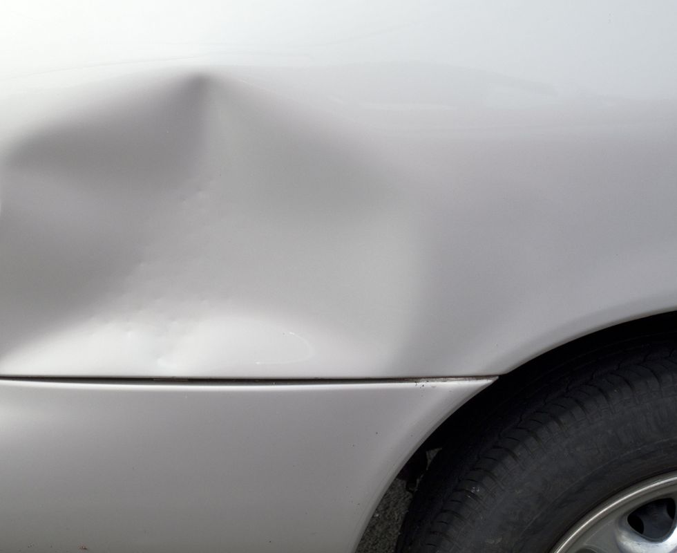 close up of a dent in a gray car exterior