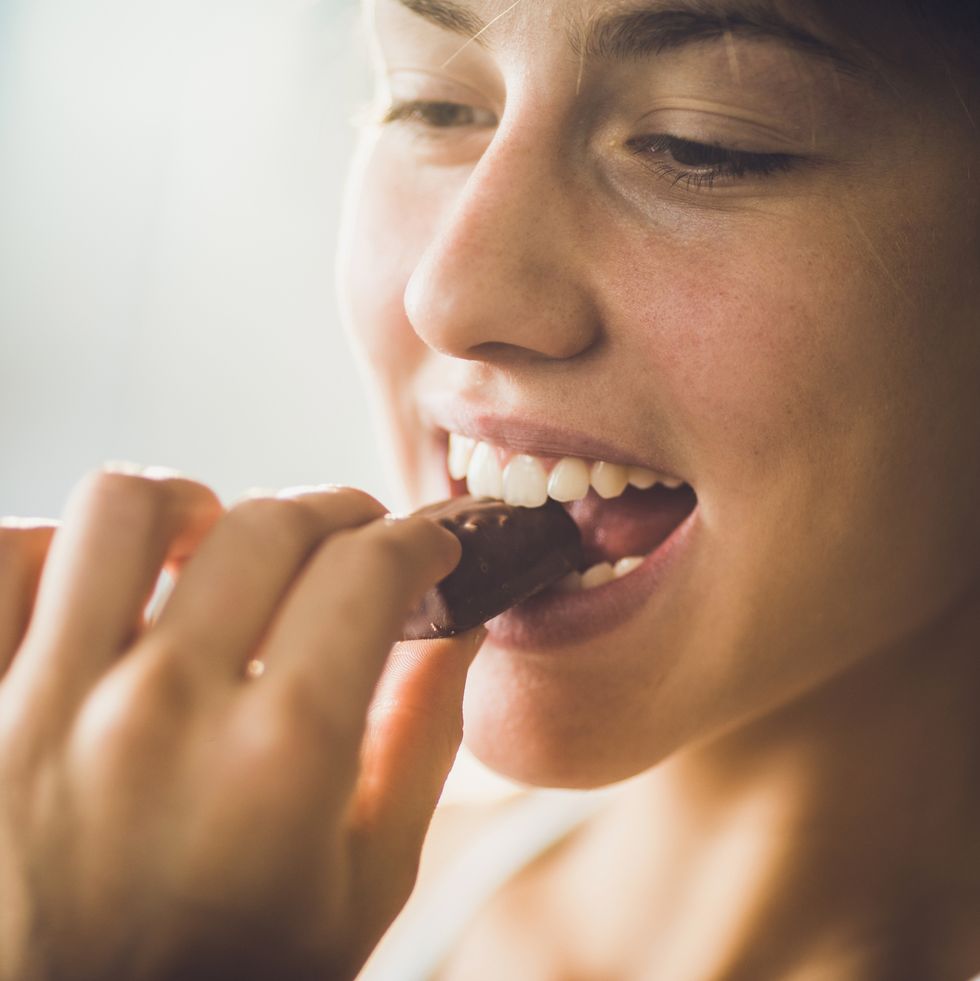close up of a happy woman eating chocolate