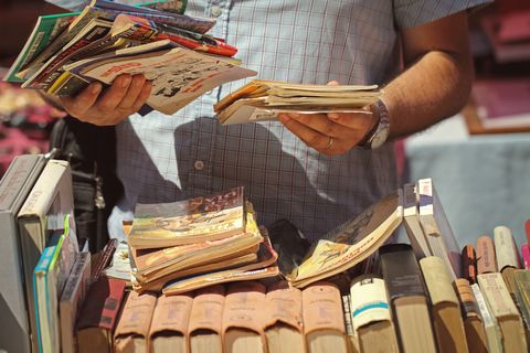 Close-Up Of A Man Holding Books At Flea Market