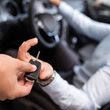 close up of a teenager receiving new car key after getting a car loan