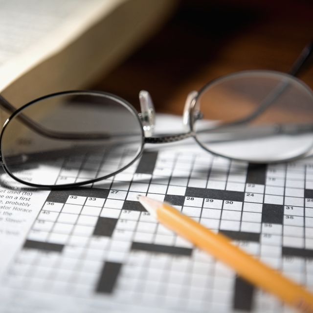 Close-up of a pencil and a pair of eyeglasses on a crossword puzzle