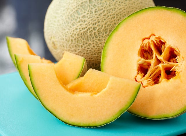 a close up of a sliced cantaloupe on a blue table