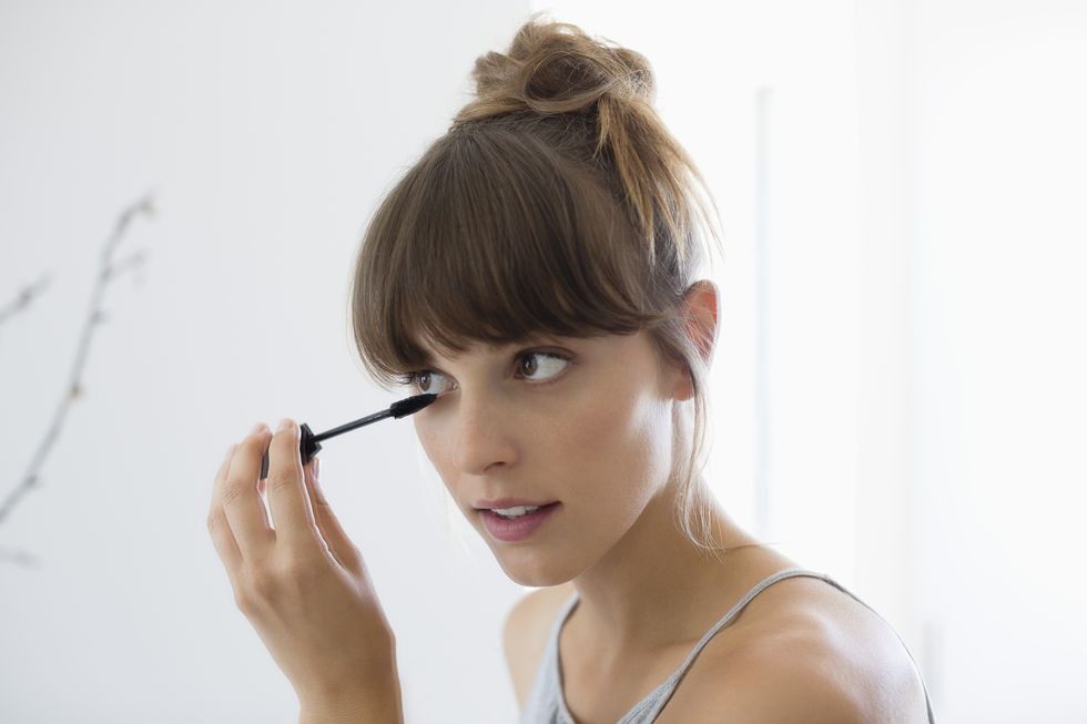 closeup of a woman applying mascara