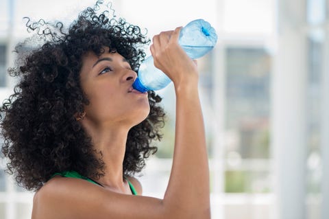 close up of a woman drinking water from a bottle