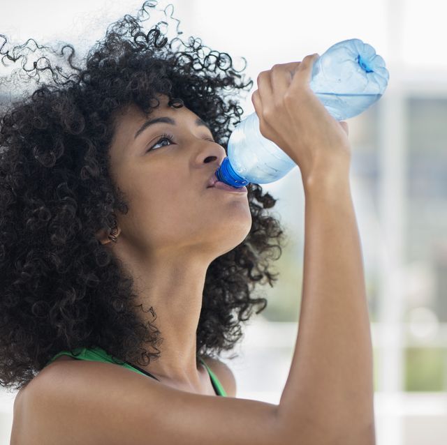 close up of a woman drinking water from a bottle