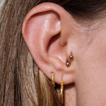 close up of a woman ear with multiple earrings
