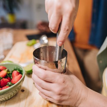 close up of a woman squeezing strawberries in the kitchen at home
