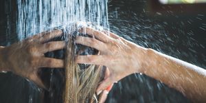 close up of a woman washing her hair while showering in the morning