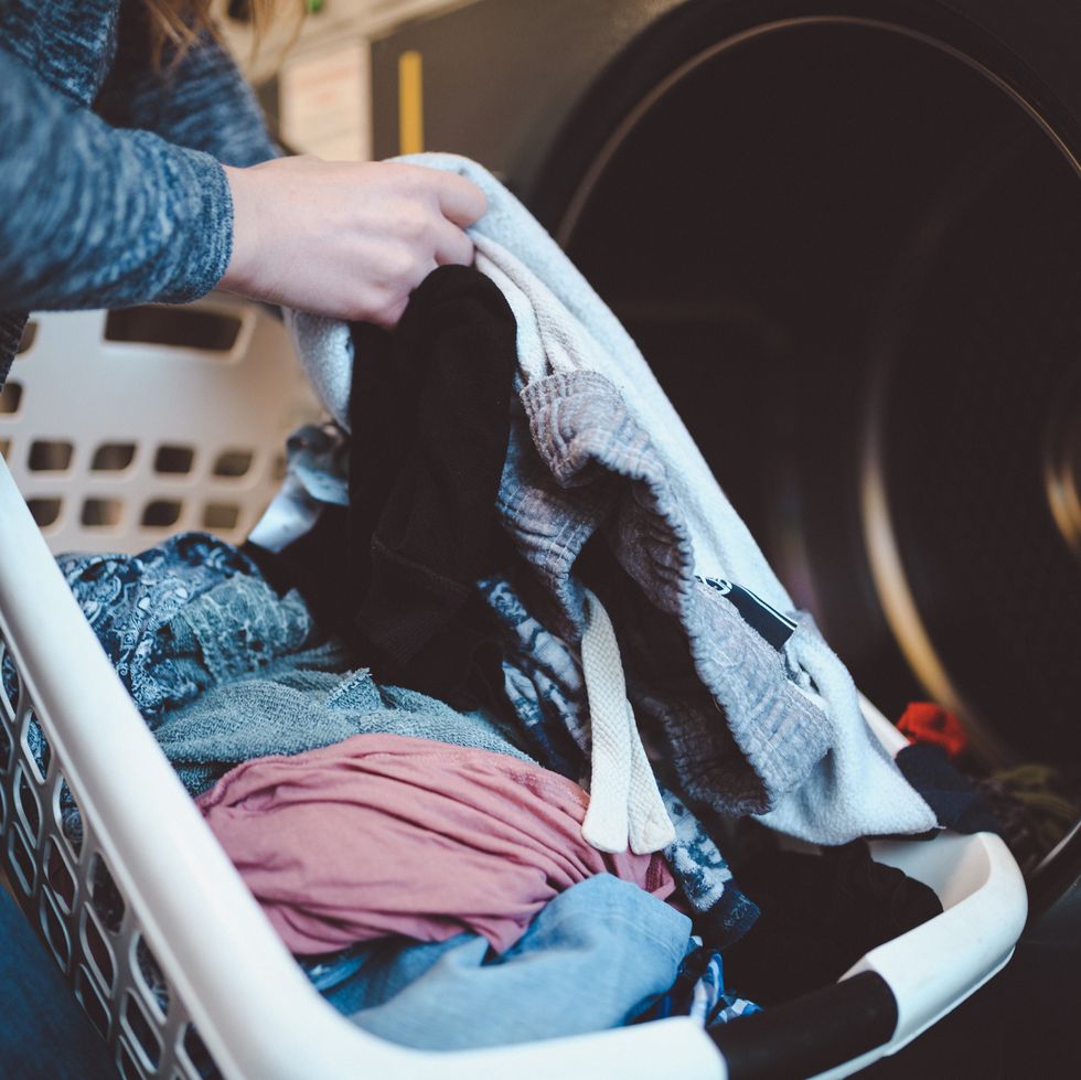 close up of a woman with a laundry basket washing clothes
