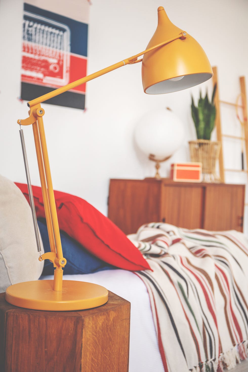 Close-up of a yellow lamp next to a bed in a bedroom interior