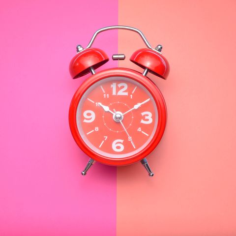 Close-Up Of Alarm Clock Over Colored Background
