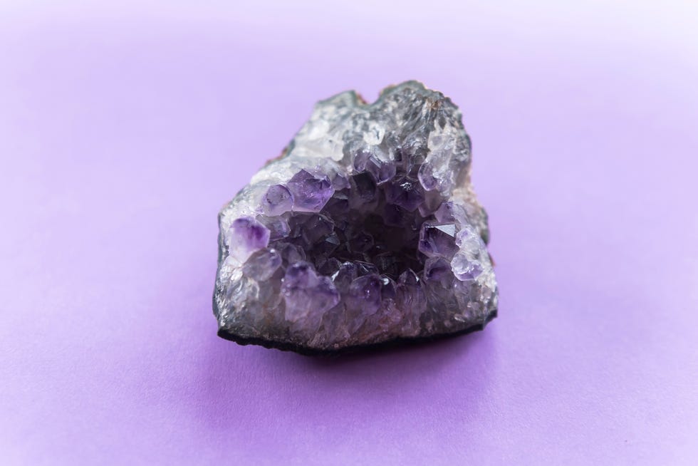 close up of amethyst crystal geode on a puple background