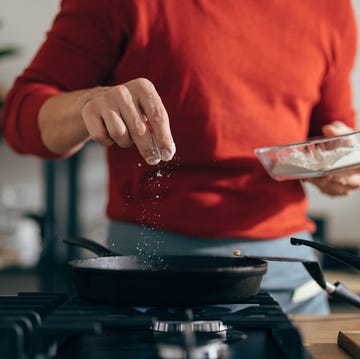 close up of anonymous man adding salt to a meal