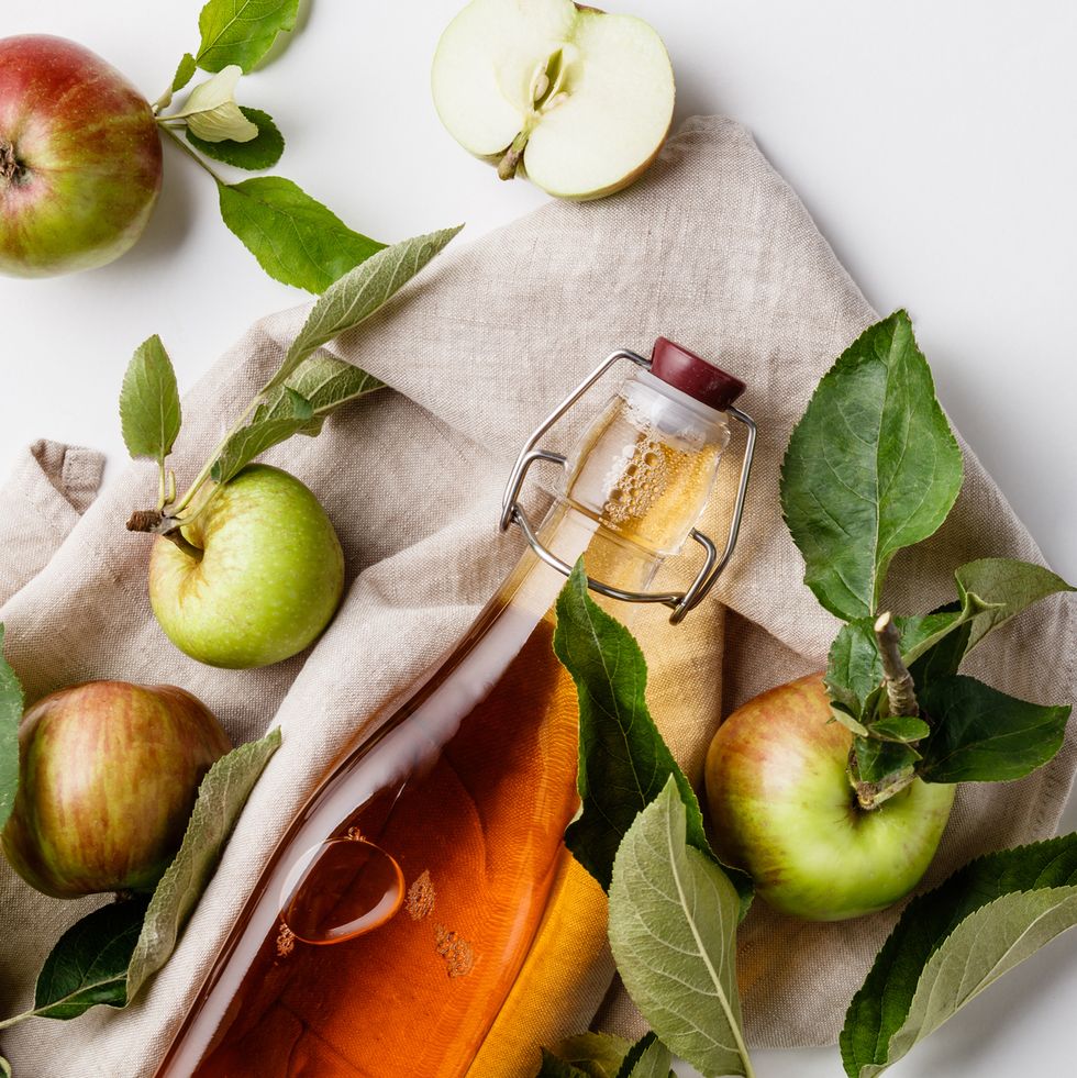 close up of apple cider vinegar in bottle against white background