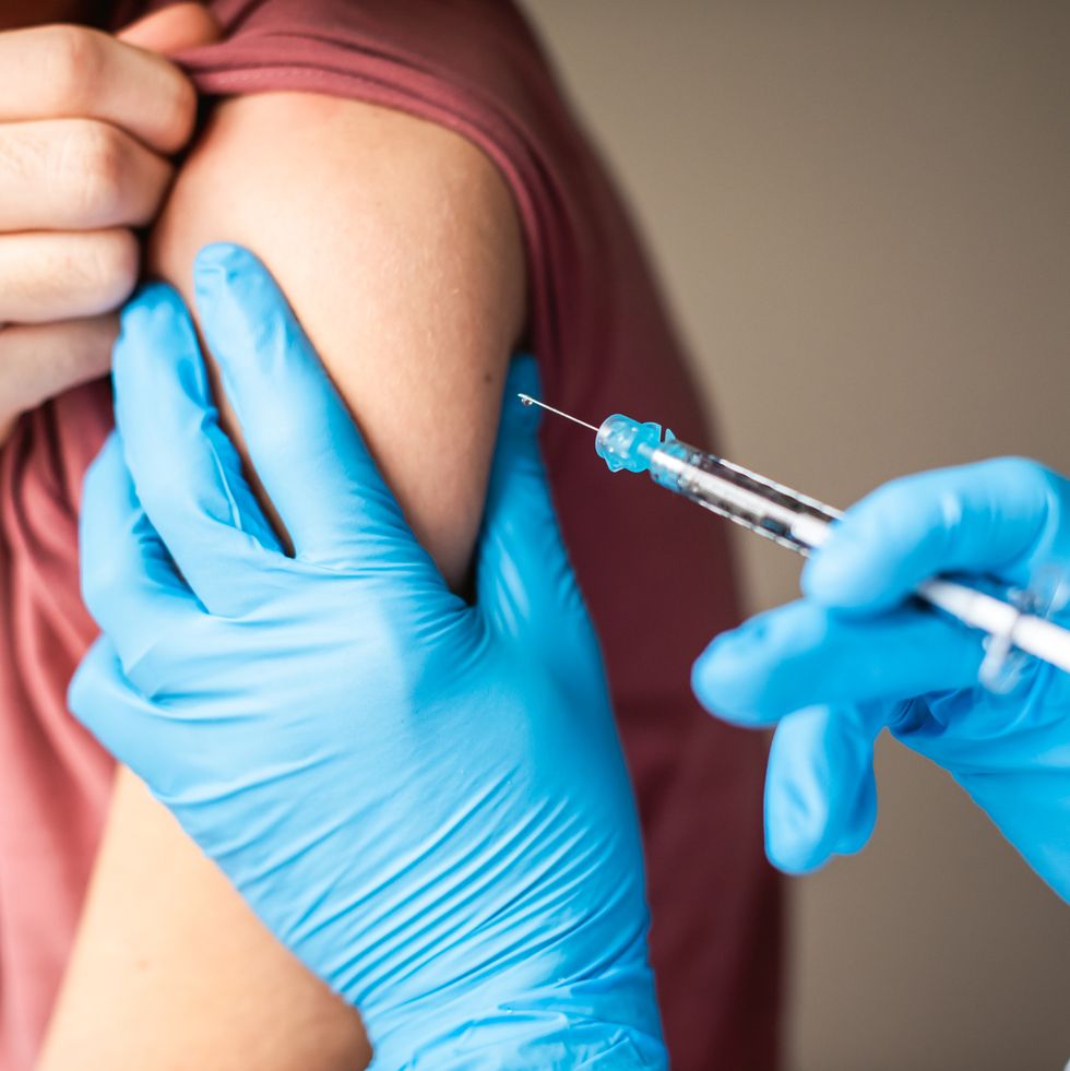close up of arm of boy getting vaccinated by doctor holding a needle