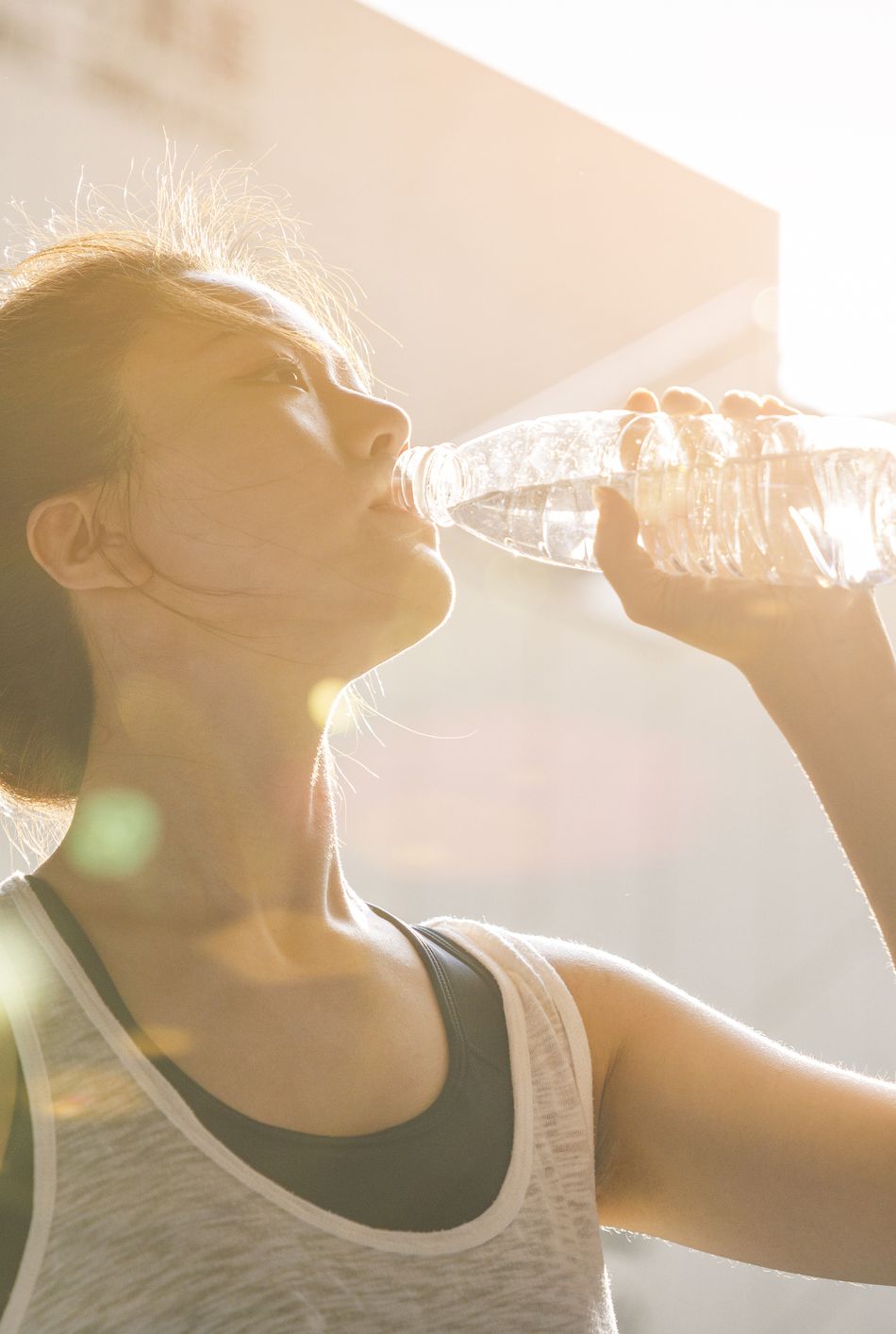 close up of asian woman drinking water after exercise