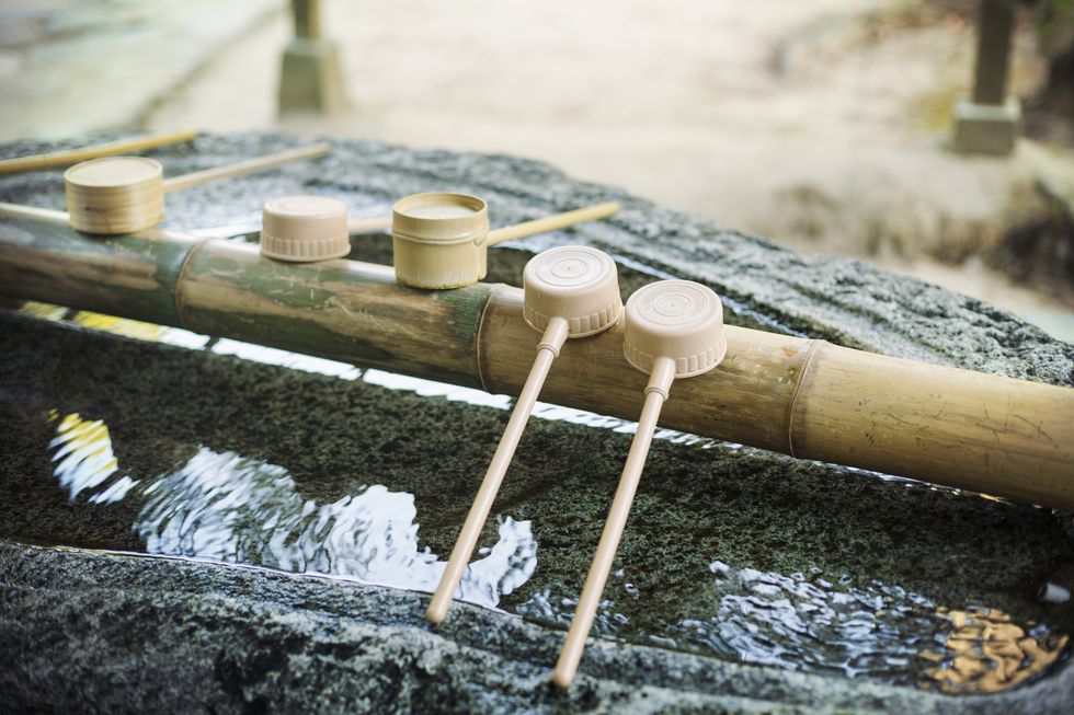 close up of bamboo water hand washing basins at shinto sakurai shrine, fukuoka, japan