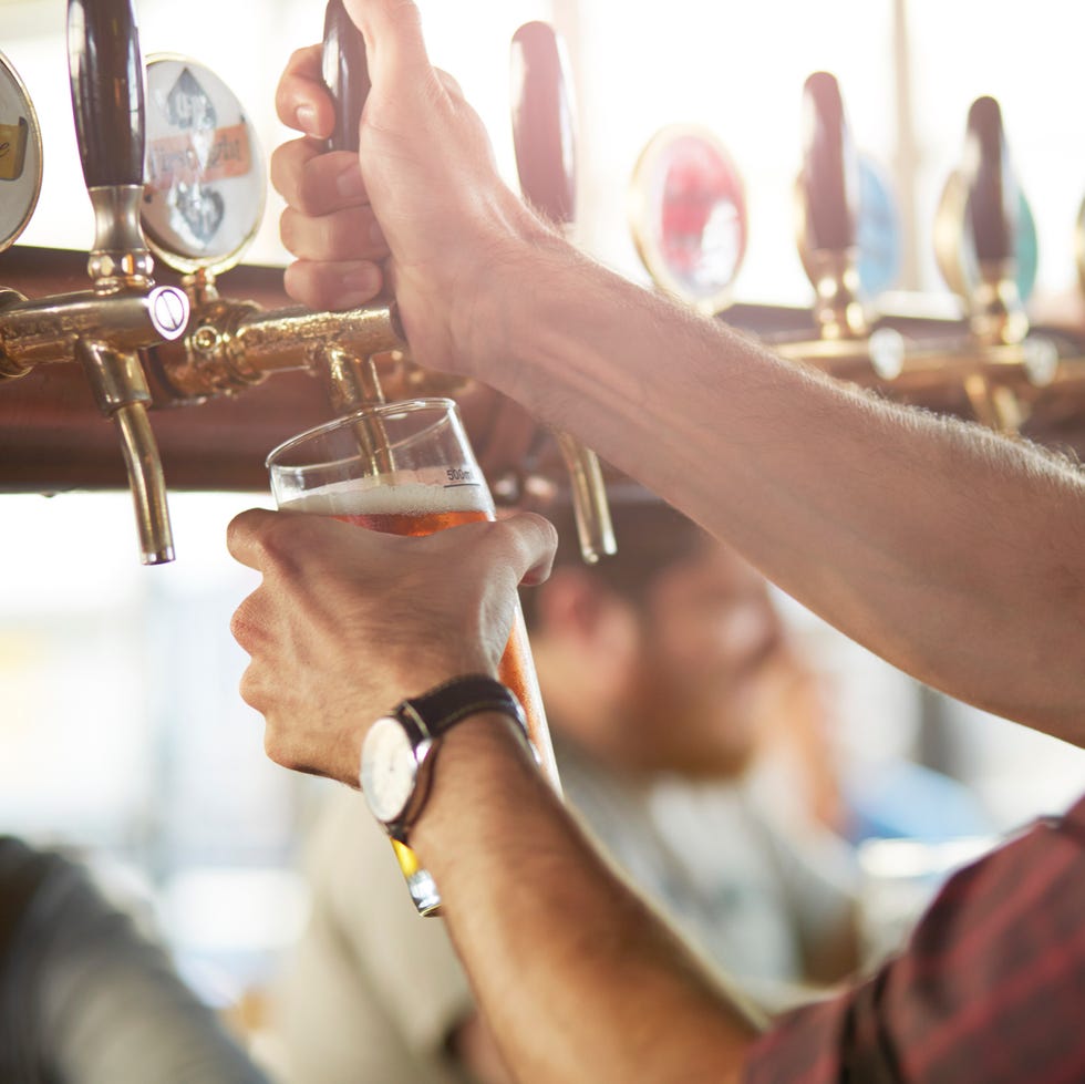 Close-up of bartender making cask beers at bar