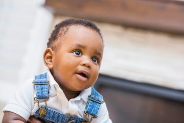 close up of a baby boy in overalls