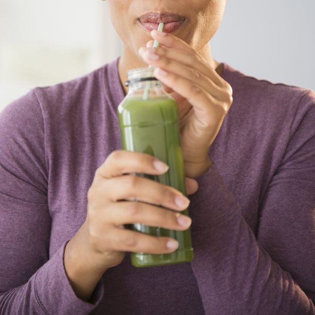 chlorophyll benefits close up of black woman drinking green smoothie