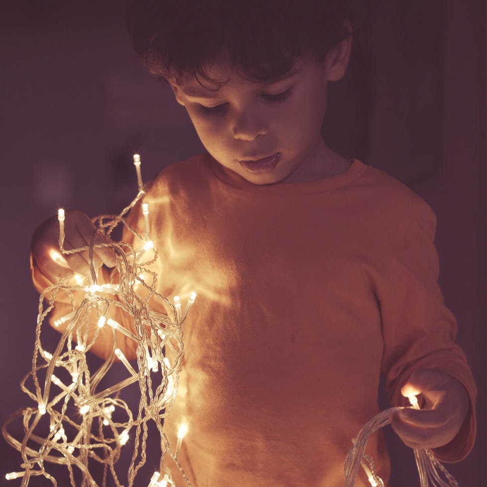 christmas symbol - Close-Up Of Boy With Fairy Lights