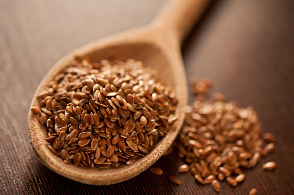 close up of brown flaxseeds on spoon at table