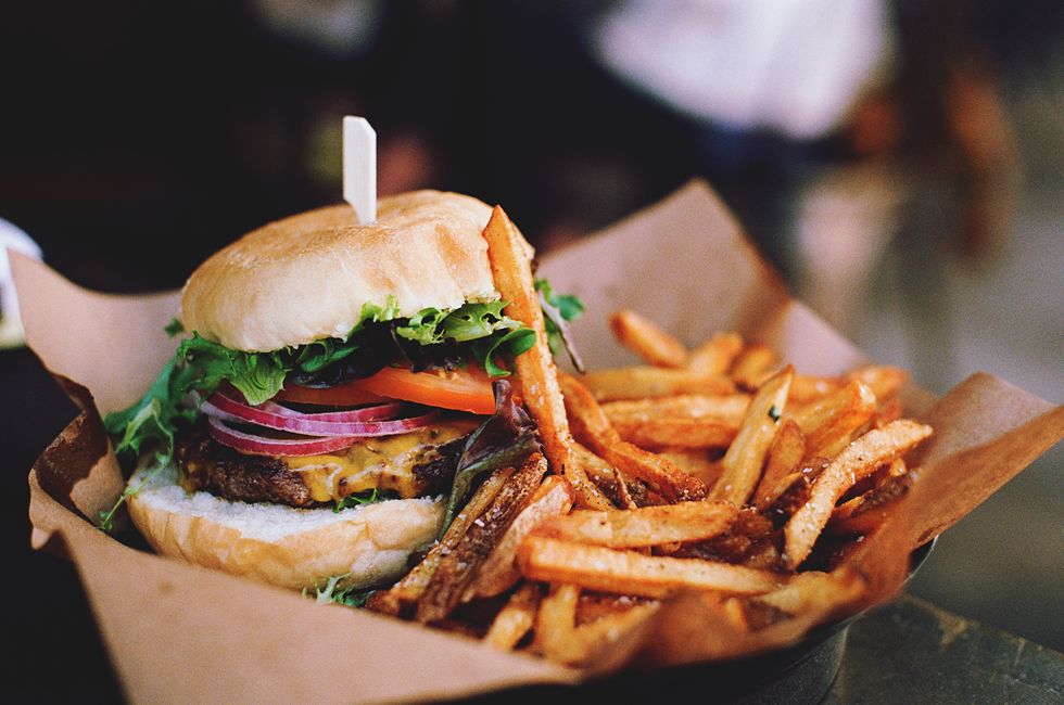 close up of burger with french fries on table