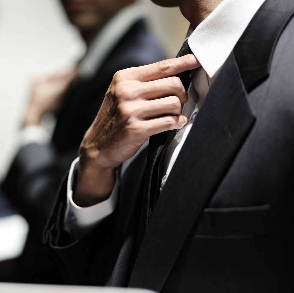 close up of businessman adjusting necktie
