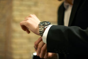 close up of businessman fastening wristwatch