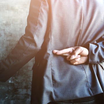 close up of businessmen shaking hands against wall