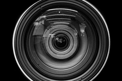 close up of camera lens against black background