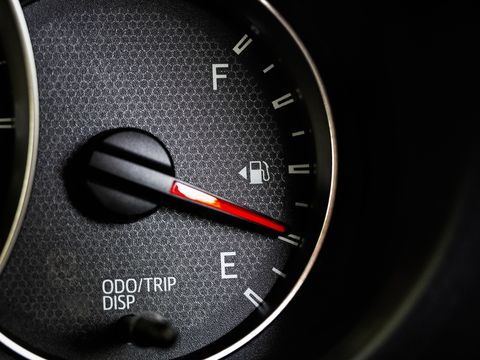 close up of car fuel gauge with red needle